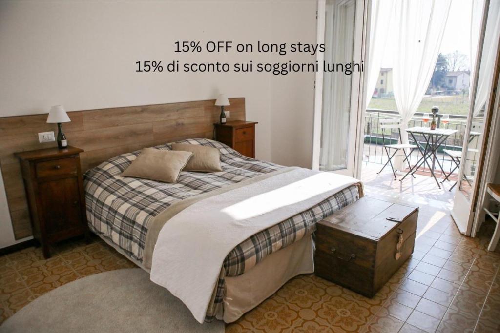 a bedroom with a large bed and a balcony at Appartamento al Birrificio in Valeggio sul Mincio