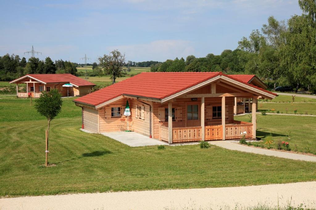 ein großes Holzhaus mit rotem Dach in der Unterkunft Alpenchalets Hotel Lambach in Seebruck