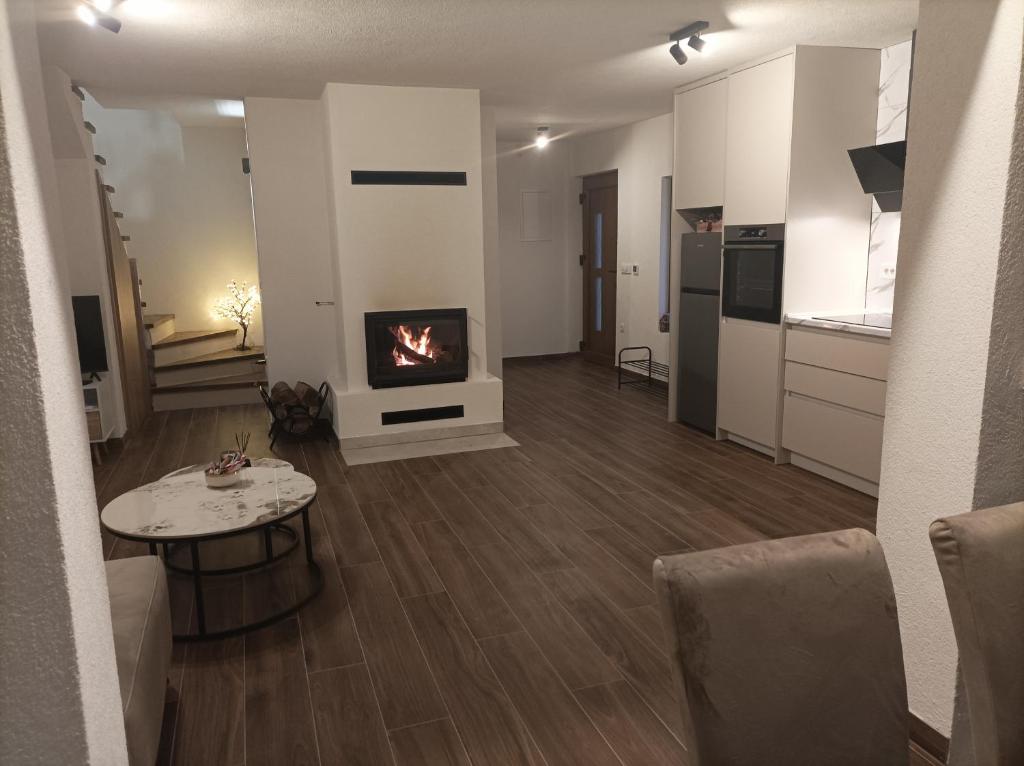 a living room with a fireplace and a table at WoodAvenue in Blidinje