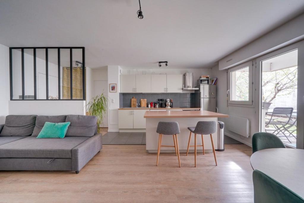 ein Wohnzimmer mit einem Sofa, einem Tisch und Stühlen in der Unterkunft Pleasant flat in Bordeaux with terrace and parking in Bordeaux