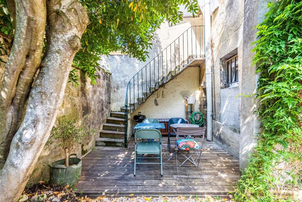 - une table et des chaises sur une terrasse couverte avec des escaliers dans l'établissement Beautiful apartment in Bordeaux with garden, à Bordeaux