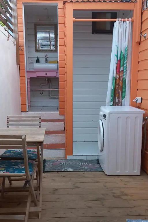 a house with a shower and a sink and a table at Chez Anne - Grand Caz in Marigot
