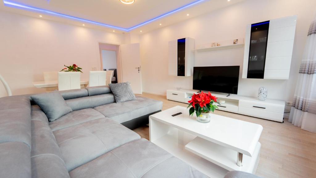 a living room with a couch and a tv at Mega Lux Apartment in Esslingen