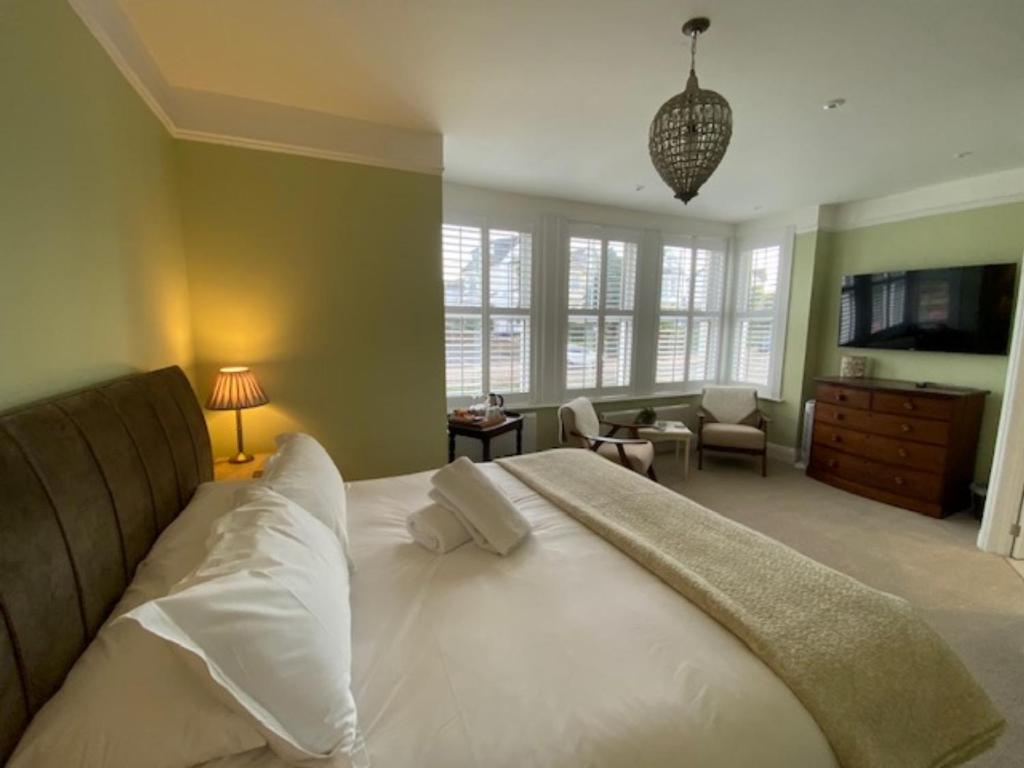 ファルマスにあるCamelot Guest Houseのベッドルーム(大型ベッド1台付)、リビングルームが備わります。