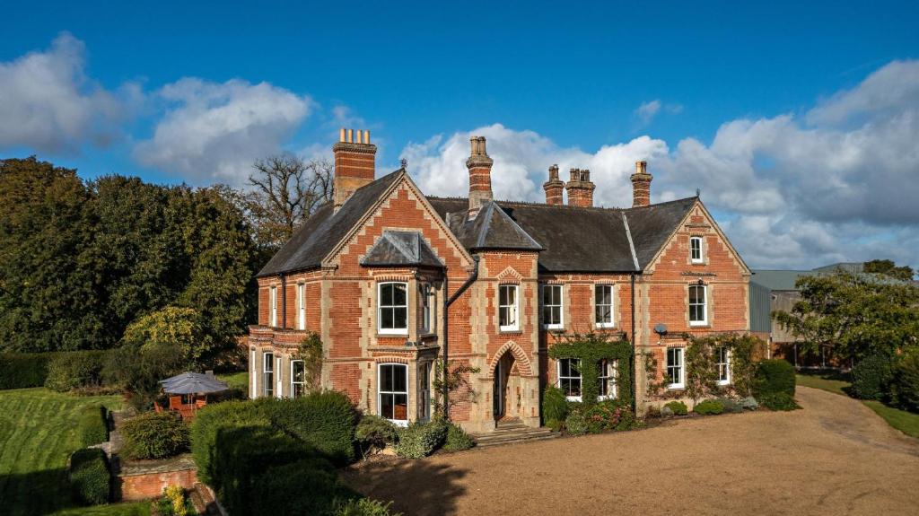 a large brick house with a black roof at Saham Grove Hall by Group Retreats in West Bradenham