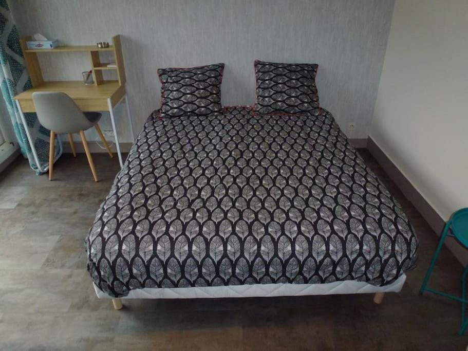 - un lit avec une couette noire dans une chambre dans l&#39;établissement Appart Limoges centre gare., à Limoges