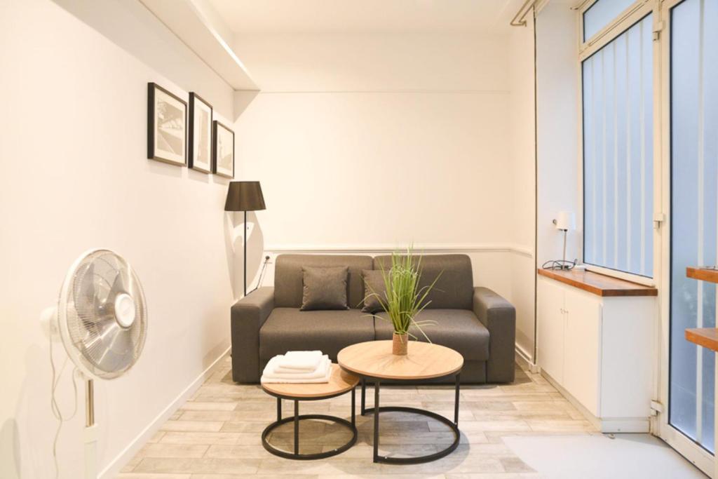 een woonkamer met een bank en een tafel bij Studio Cocoon Near Eiffel Tower in Parijs