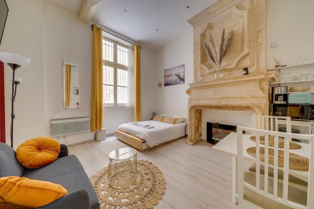 un salon avec une cheminée et un lit dans l'établissement Charming hypercentre apartment Bordeaux, à Bordeaux