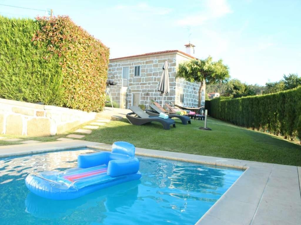 einen Pool mit Stühlen und einem aufblasbaren Pool in der Unterkunft Quaint and Peaceful Barcelos Villa - 3 Bedrooms - Villa Mycenaean - Private Pool and Large Garden - North Portugal in Barcelos