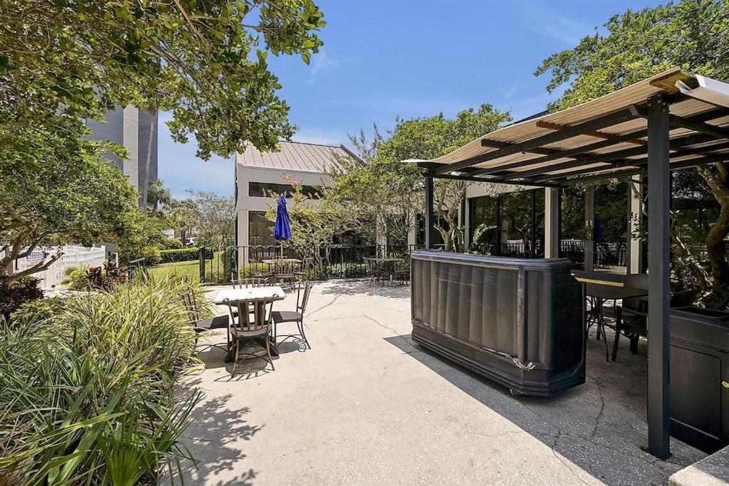 een patio met een tafel en stoelen en een paviljoen bij Enclave Refurbished Condo: Just 2mi to Universal! in Orlando