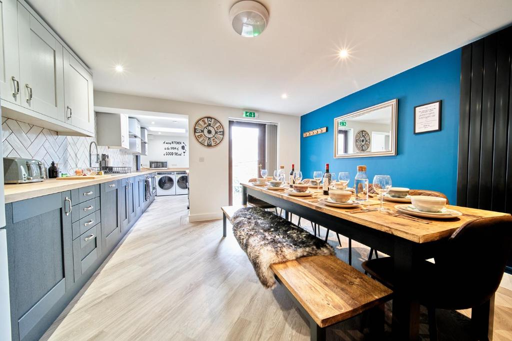 a kitchen with a long table and a blue wall at Belfry House in Bristol