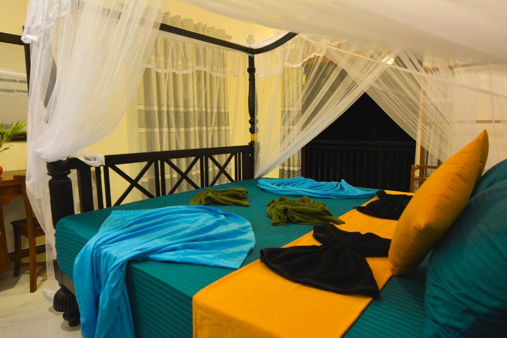 a bedroom with a bed with a canopy at Monkey Island Hotel in Hikkaduwa