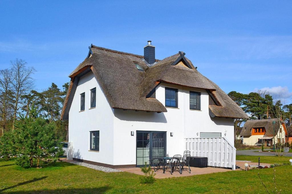 a large white house with a thatched roof at Doppelhaushälfte Dock No 7 0 in Zirchow in Zirchow