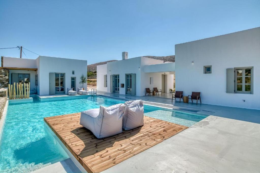 a villa with a swimming pool with a couch at Lil Paros Luxury suites in Dhragoulás