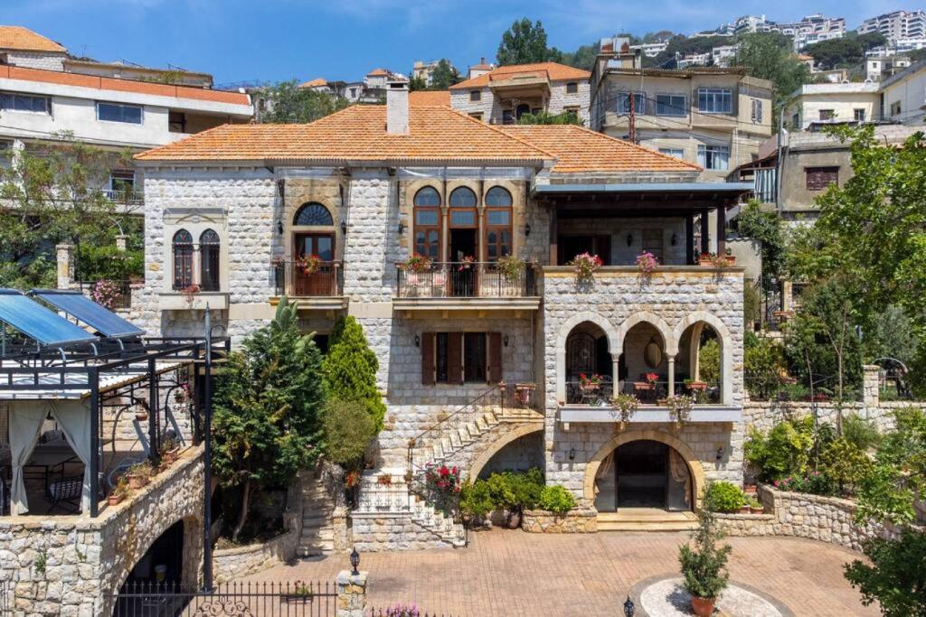 a large stone house with a tile roof at Authentic Villa with Pool and Garden in Beit Chabeb 