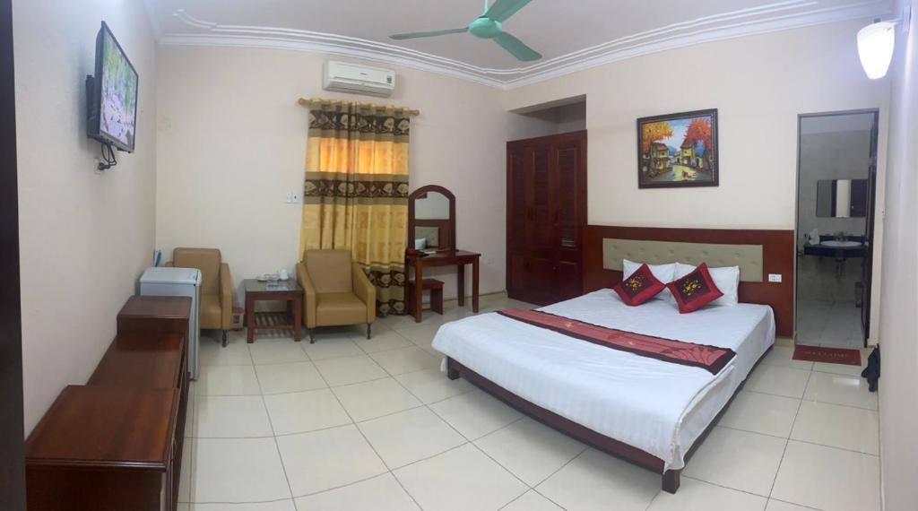 sypialnia z 2 łóżkami, stołem i biurkiem w obiekcie ANH ĐÀO HOTEL LẠNG SƠN w mieście Lạng Sơn