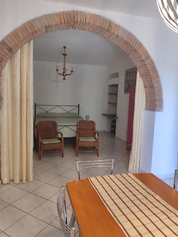 a dining room with an archway and a table and chairs at Happy Flat in Riparbella