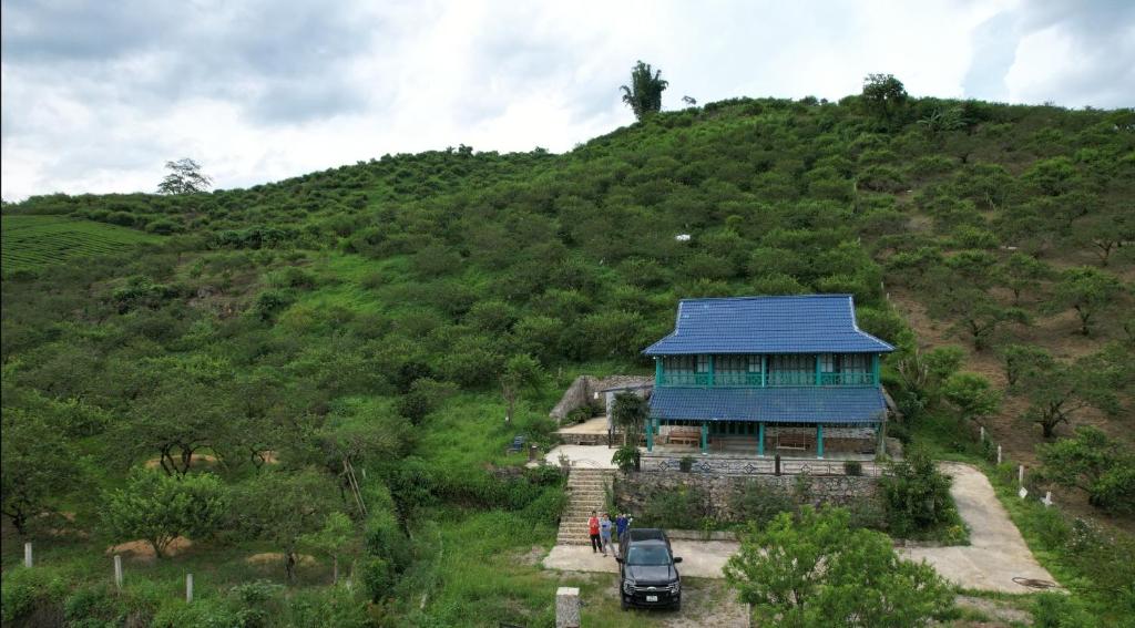 una casa con techo azul en una colina en Vừng Homestay - Mộc Châu, en Mộc Châu