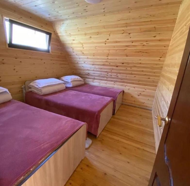 um quarto com 2 camas num chalé de madeira em Kolsay Village em Kurmenty