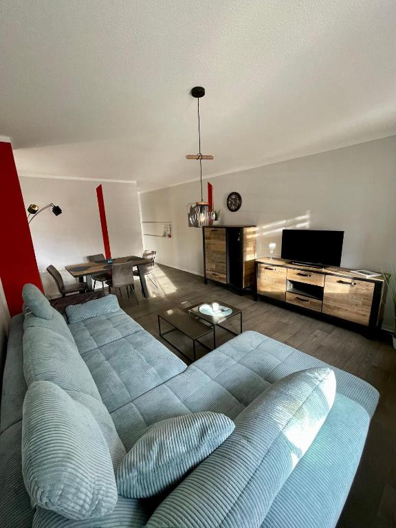 a living room with a blue couch and a table at Ferienwohnung Teichidyll Altenburg in Altenburg