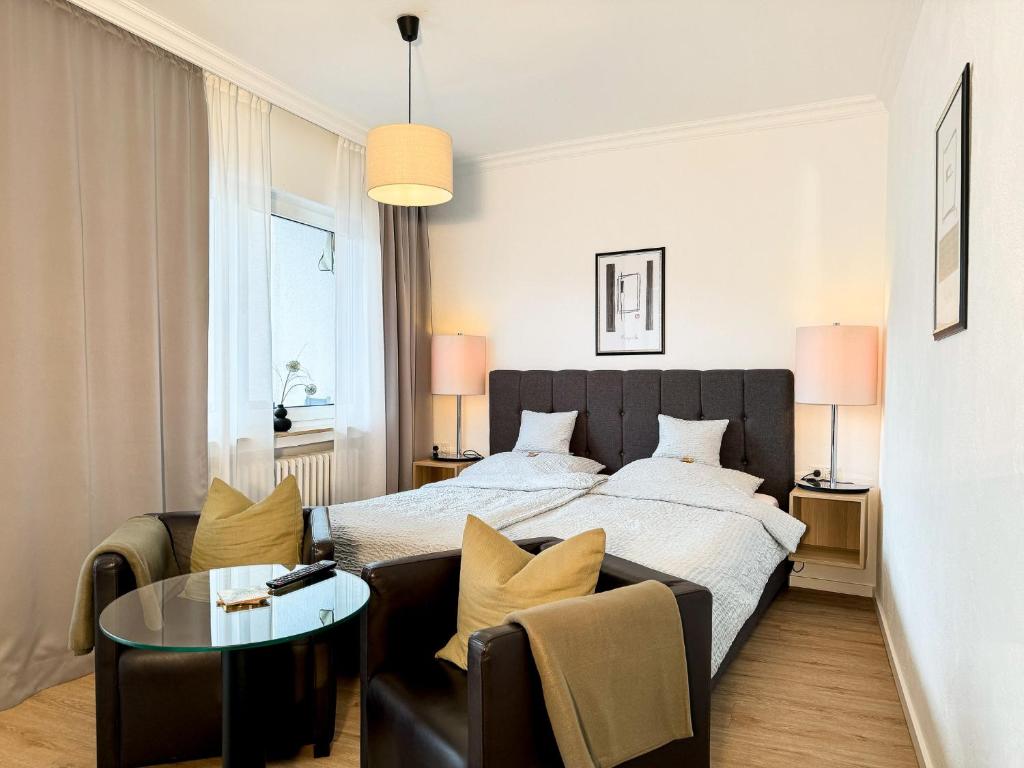 ein Schlafzimmer mit einem Bett, einem Sofa und einem Tisch in der Unterkunft AhrPart Hotel Central in Bad Neuenahr-Ahrweiler