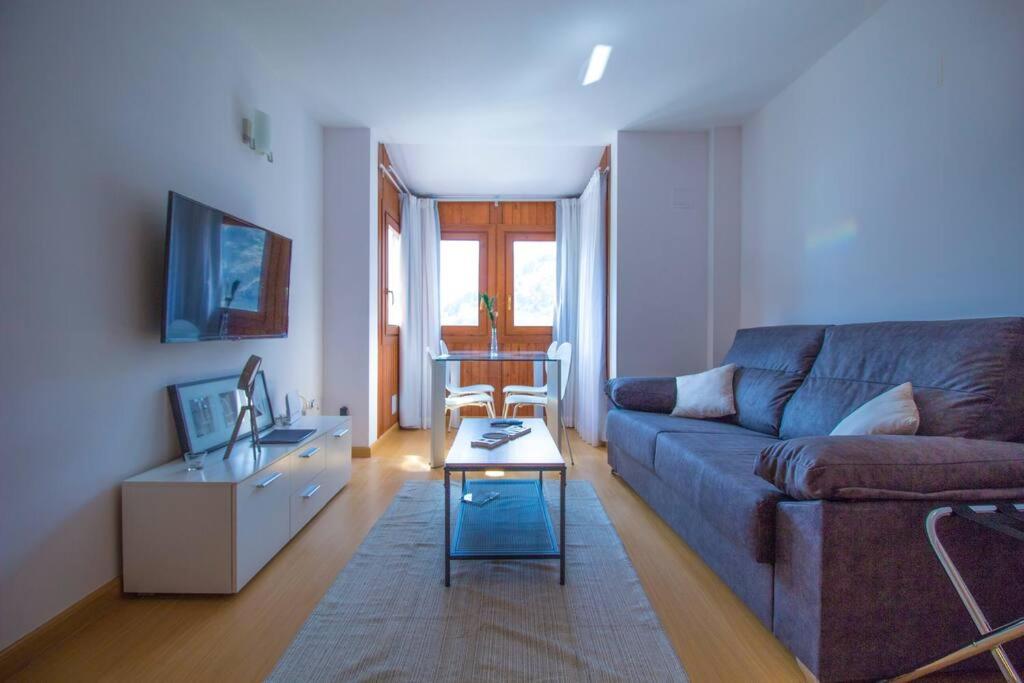 een woonkamer met een bank en een tafel bij 1. APT cerca a pistas de esquí y la Vall d'Incles in Soldeu