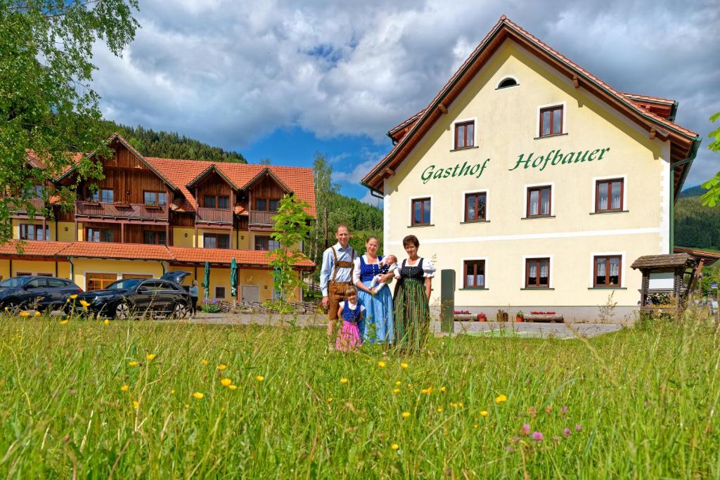 eine Gruppe von Personen, die auf einem Feld vor einem Gebäude stehen in der Unterkunft Gasthof Hofbauer in Breitenau am Hochlantsch
