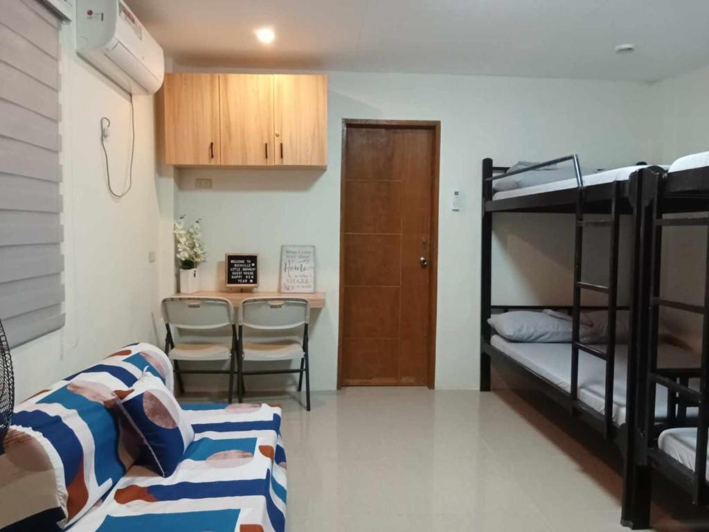 ein Wohnzimmer mit Etagenbetten und einem Tisch in der Unterkunft RICHVILLE LITTLE BORACAY GUEST HOUSE in Calatagan