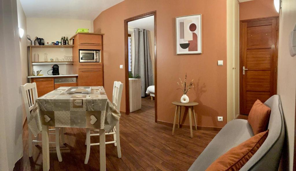 une salle à manger et une cuisine avec une table et des chaises dans l'établissement Appartements de la houle, à Cancale