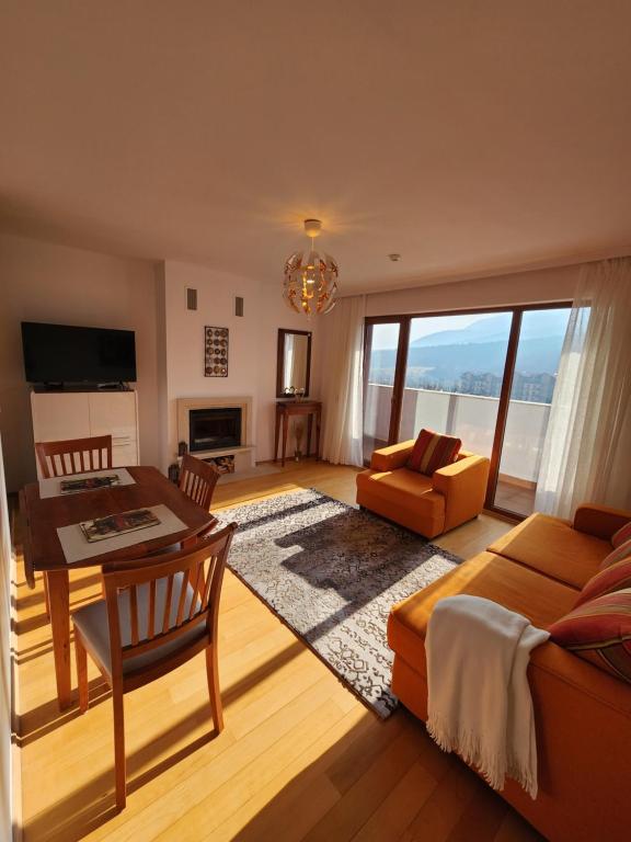 uma sala de estar com um sofá e uma mesa em One Bedroom Apartment Pirin Lodge em Bansko