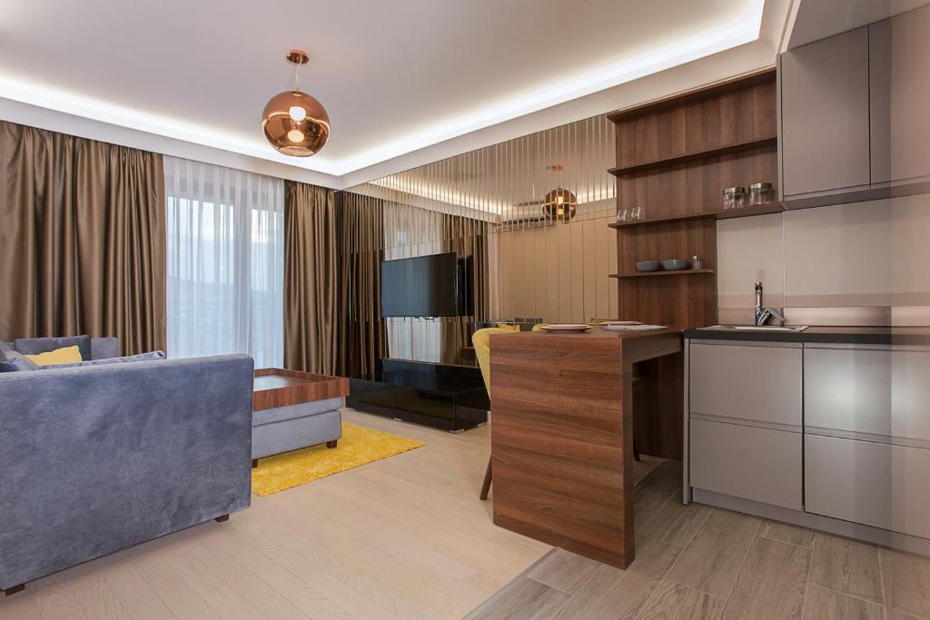 a kitchen and living room with a couch and a table at GM SkyView Luxury Flatiron apartment Skopje in Skopje