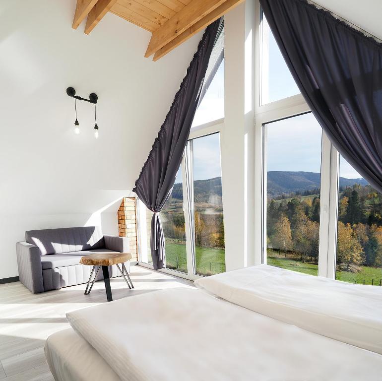 sypialnia z łóżkiem i dużym oknem w obiekcie Widokówka Kletno w Stroniu Śląskim