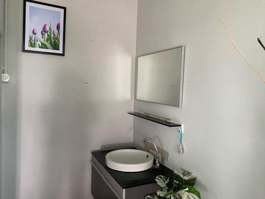 a bathroom with a white toilet and a mirror at วิวเขื่อน โฮมสเตย์ 