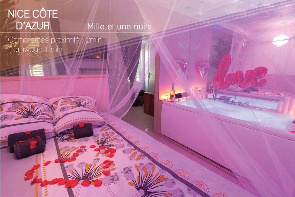 Dormitorio rosa con cama en la ventana en AG 1 Love Balnéo Clim 1min plage,, en Niza