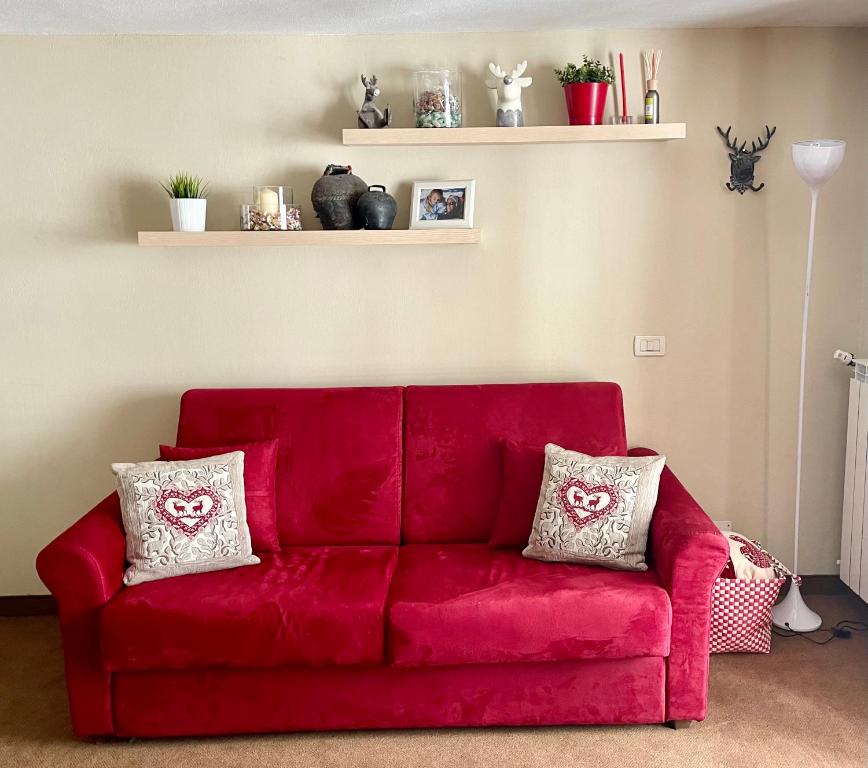 a red couch in a living room with two pillows at Alpine Studio with Garage in Breuil