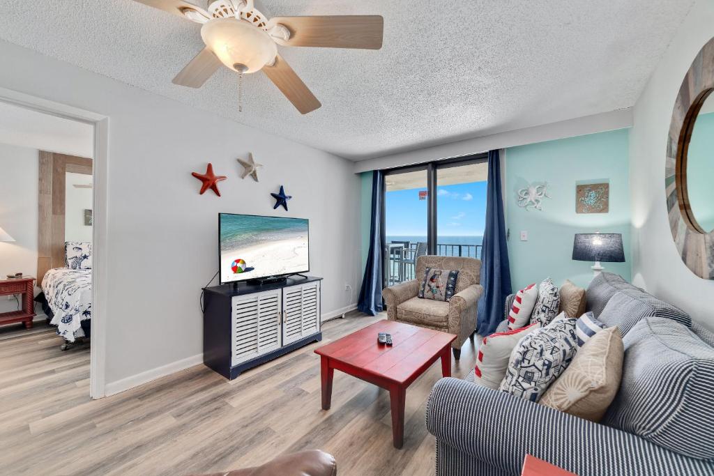 a living room with a couch and a tv at Phoenix 1093 in Orange Beach