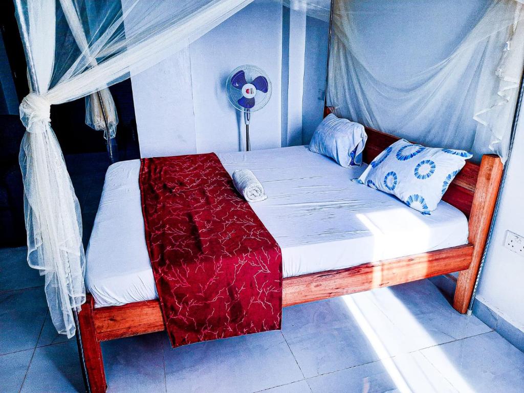 een bed in een kamer met een baldakijn bij Studio at Kisimani Heights Apartment. in Mombasa