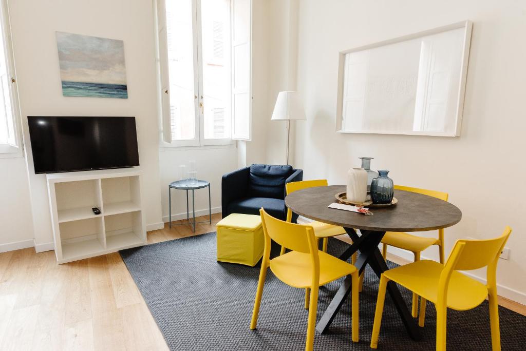 ein Wohnzimmer mit einem Esstisch und gelben Stühlen in der Unterkunft Open space nel pieno centro di Brescia in Brescia