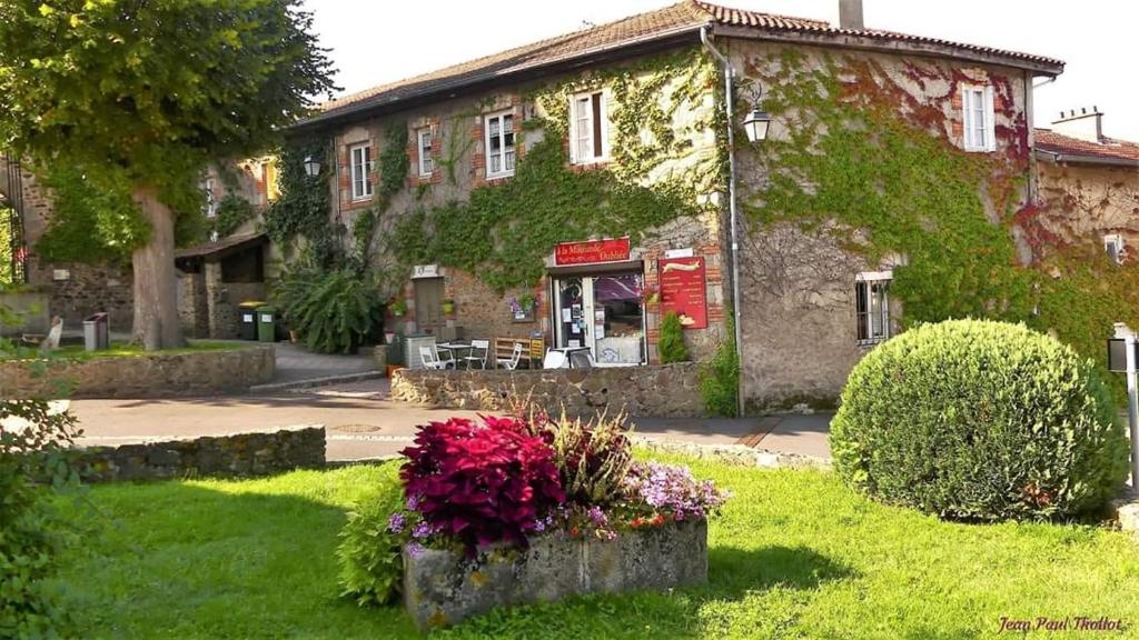 an old building with flowers in front of it at La Ferriere in Saint-Médard-en-Forez
