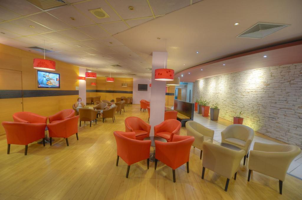 a waiting room with orange chairs and a table at The Preluna Hotel in Sliema
