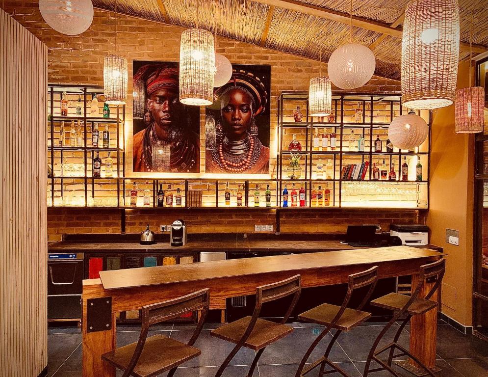 a bar with two statues of two women on the wall at Le Patio in Lomé