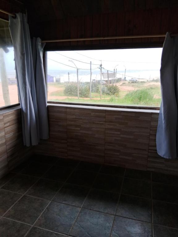 a bathroom with a window with a view of a field at Cabaña frente al mar in Punta Del Diablo