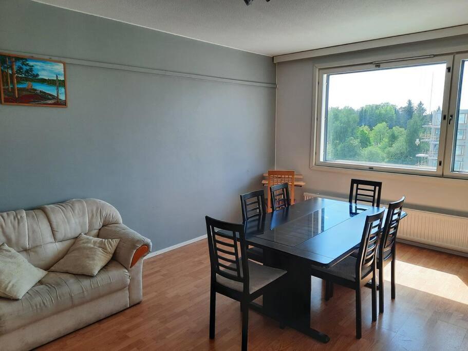 a living room with a table and chairs and a couch at 50m2 Apartment FREE Parking and Laundry, 20min to Center in Espoo