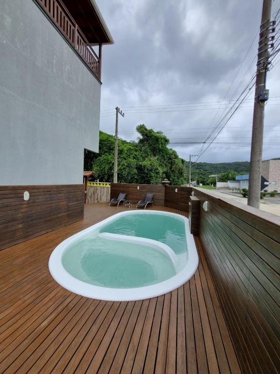 a hot tub on the deck of a house at Siri Mariscal Bombinhas C Piscina in Bombinhas