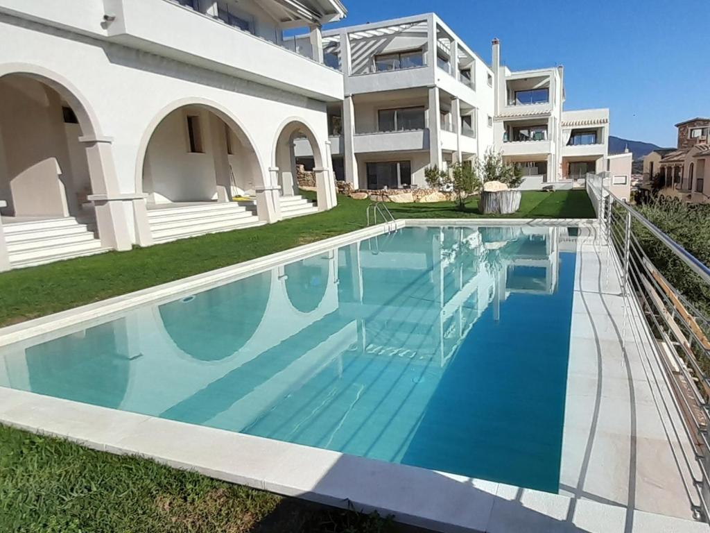 a swimming pool in front of a building at Villasimius Appartamento "Il Ginepro" in Villasimius
