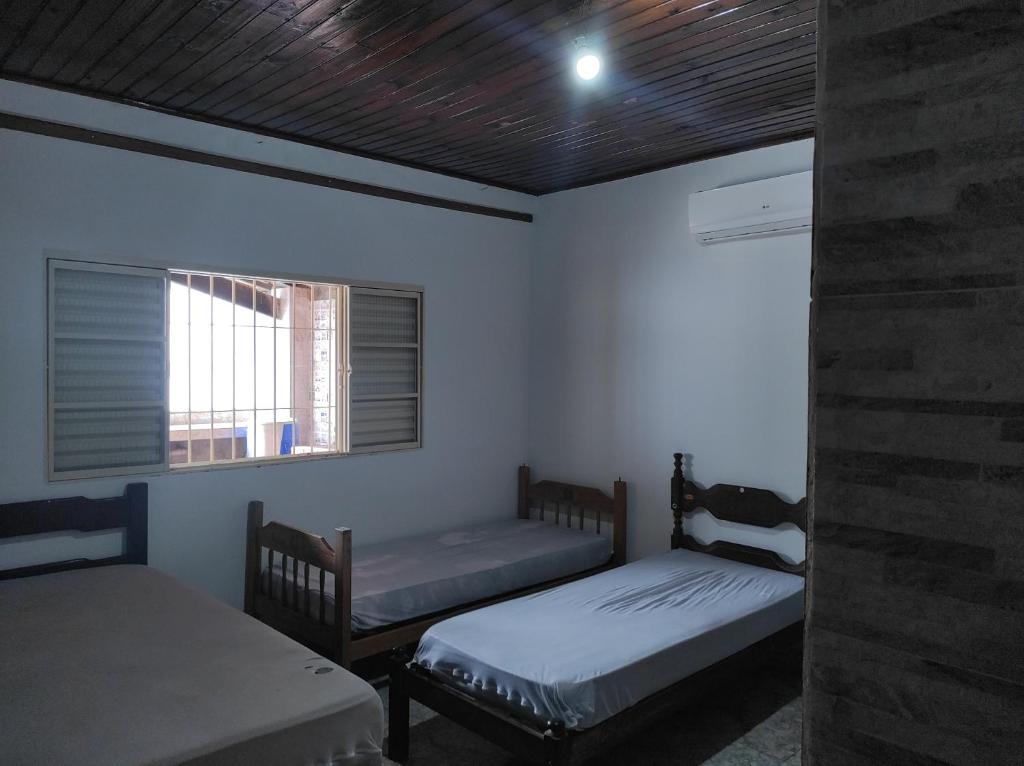 a room with two beds and a window at Casa PARA FINAIS DE SEMANA E TEMPORADA EM UBATUBA in Ubatuba