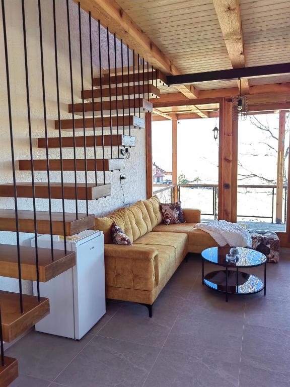a living room with a couch and a staircase at Vikendica Nina 2 in Zlatibor