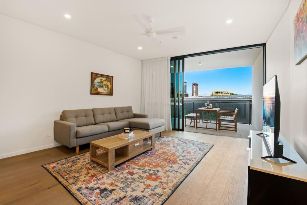 a living room with a couch and a table at Excellent location Luxury 2BR apt w carpark in Brisbane