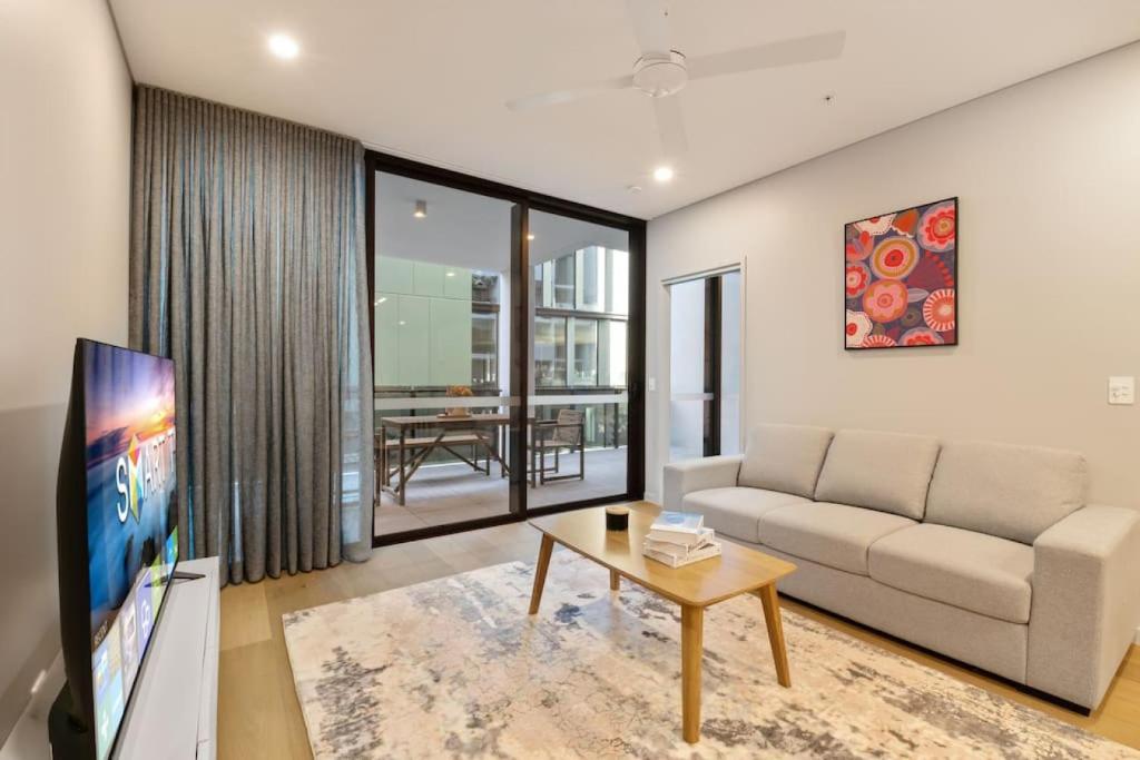 a living room with a couch and a tv at 1BR Luxury apt at prime location w carpark in Brisbane