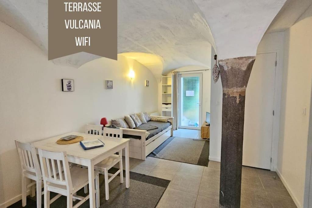 een woonkamer met een tafel en een bank bij La Petit Ourse - Wifi - Terrasse - Vulcania in Saint-Ours